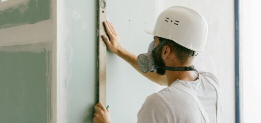 A construction worker using a leveler to ensure wall accuracy, showcasing precision.
