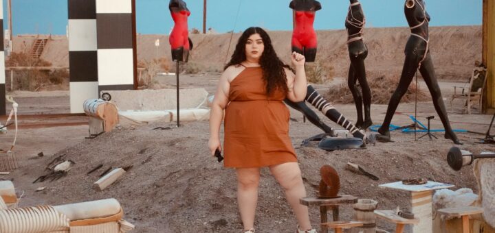 a woman standing in front of a group of mannequins